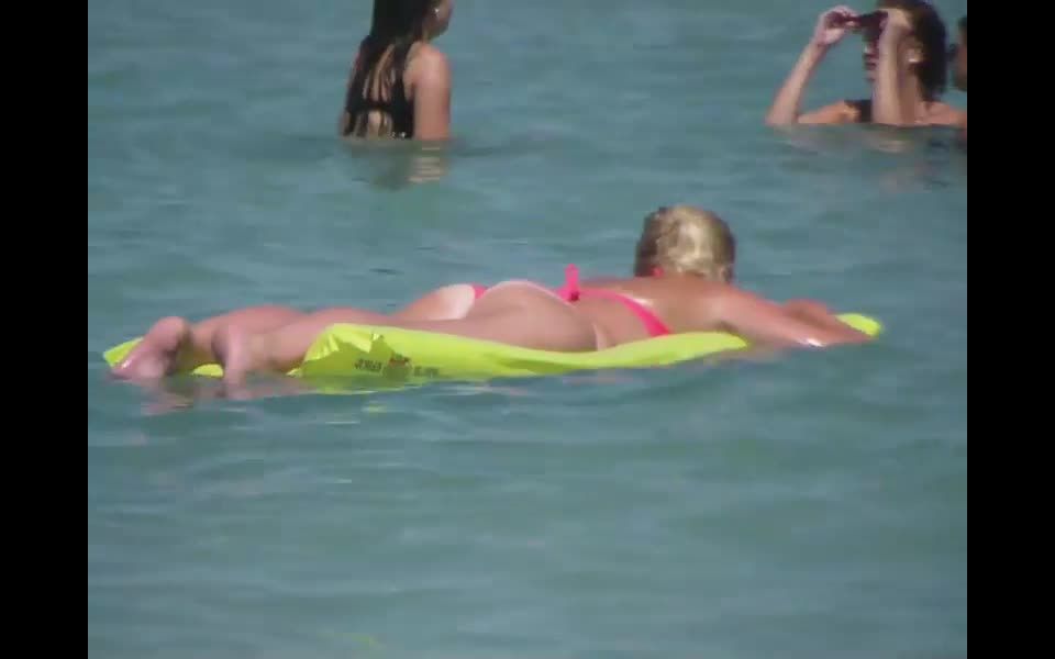 Pale buttocks in a pink thong bikini