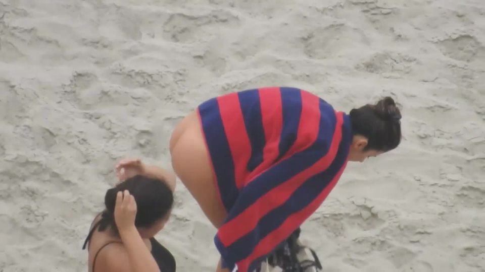 Beautiful woman gets dressed on beach